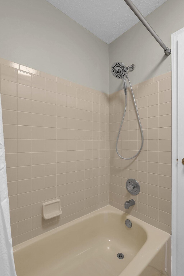 full bathroom with a textured ceiling and shower / tub combo