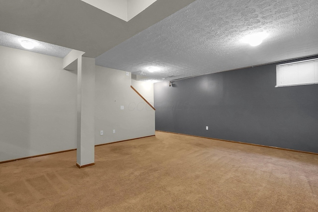 below grade area featuring carpet floors, a textured ceiling, and baseboards