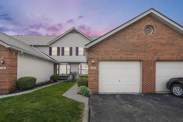 view of front of home featuring an attached garage, aphalt driveway, and brick siding