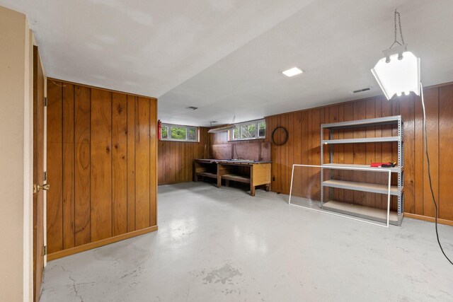basement featuring wood walls and visible vents