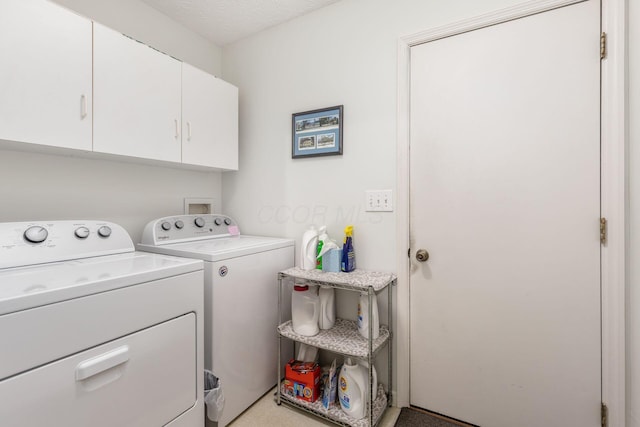 clothes washing area featuring cabinet space and washer and dryer