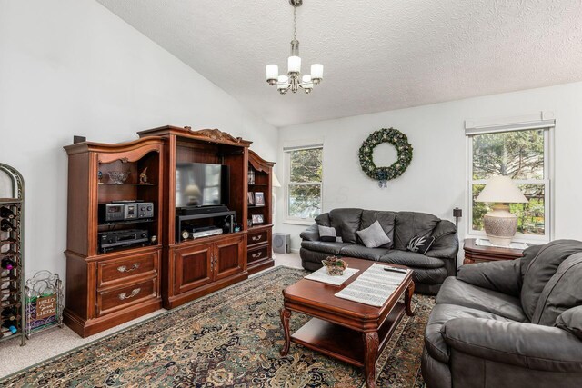 carpeted living room with a healthy amount of sunlight, vaulted ceiling, a textured ceiling, and a chandelier