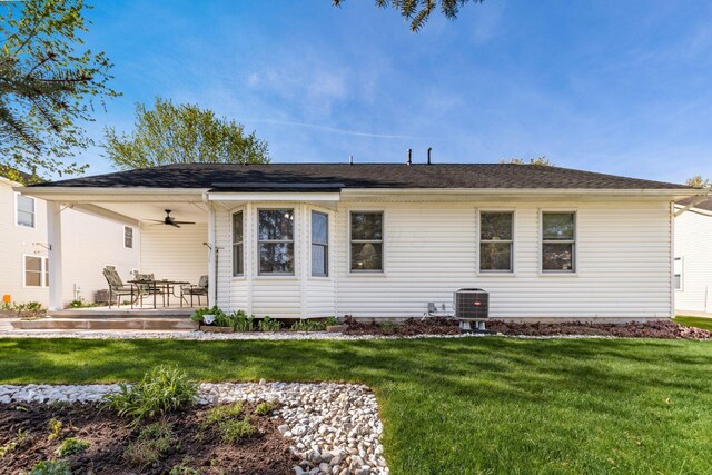 back of property featuring a ceiling fan, a yard, and central AC unit