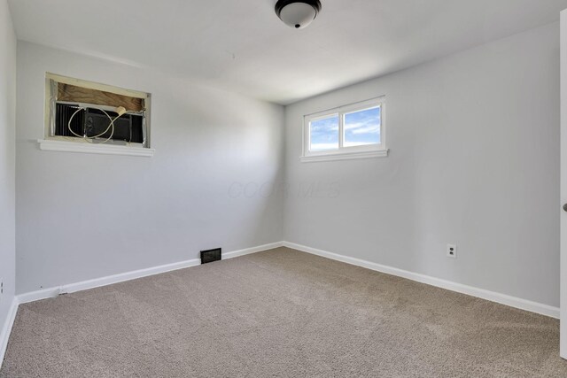 carpeted empty room featuring baseboards
