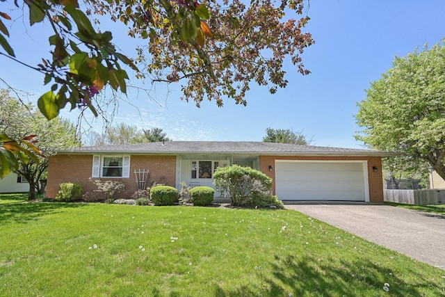 ranch-style house featuring brick siding, fence, aphalt driveway, a front yard, and an attached garage