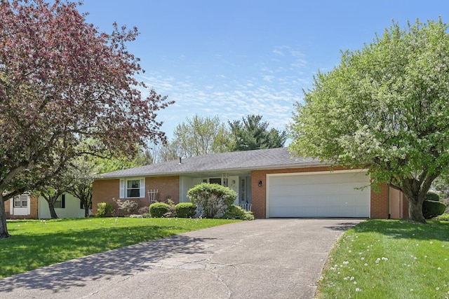 ranch-style house featuring a garage, brick siding, driveway, and a front yard