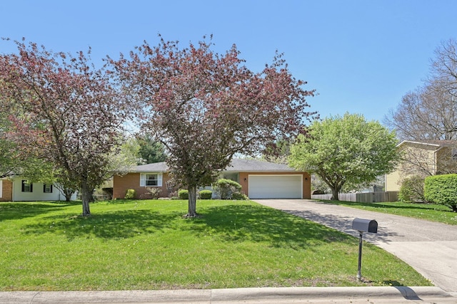 view of front of home featuring a front lawn, driveway, an attached garage, and fence