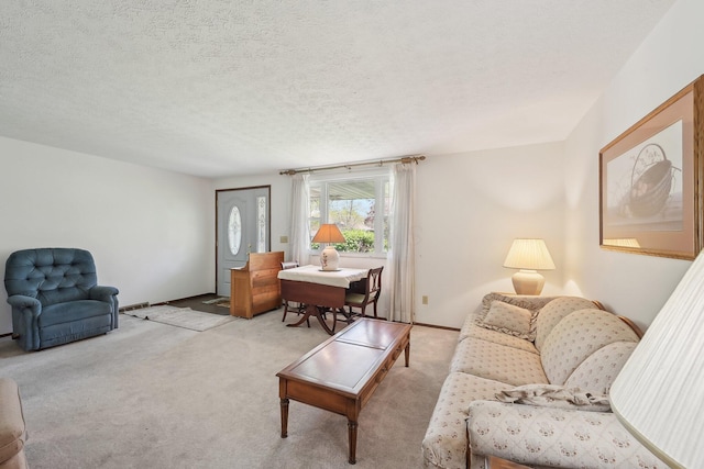 carpeted living area with a textured ceiling and baseboards