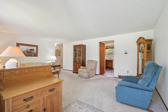 living area with light carpet and baseboards