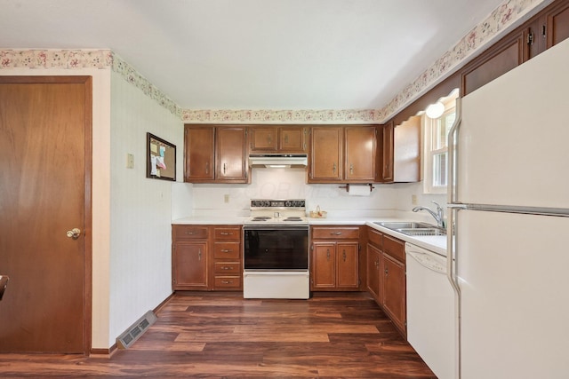 kitchen featuring a sink, visible vents, wallpapered walls, under cabinet range hood, and white appliances