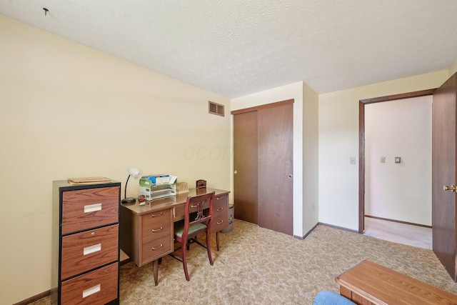home office featuring light colored carpet, visible vents, a textured ceiling, and baseboards