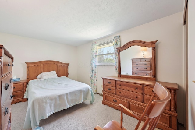 bedroom with a textured ceiling and light carpet