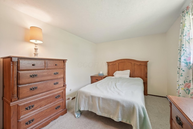 bedroom featuring baseboards and light carpet
