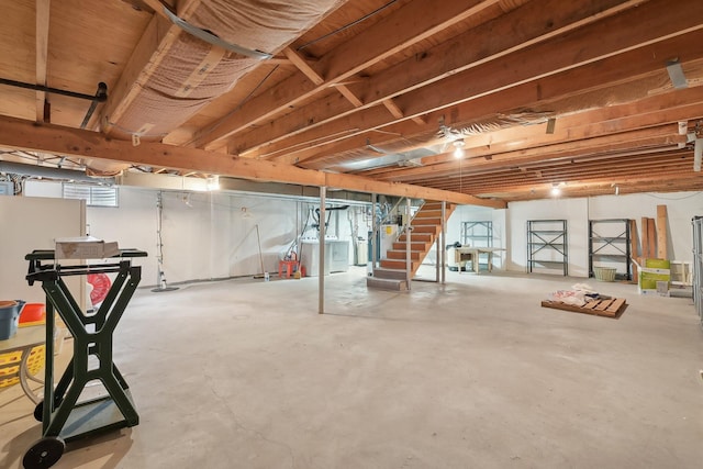 basement with water heater, stairway, and independent washer and dryer