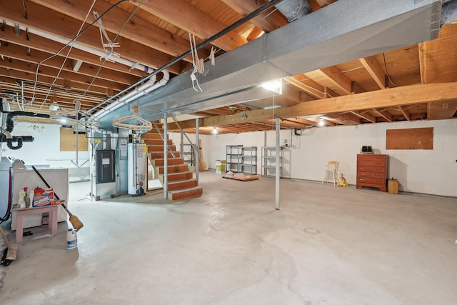 unfinished basement featuring gas water heater and stairs
