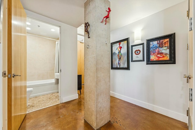 hall with concrete floors, recessed lighting, and baseboards