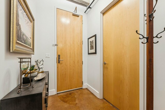entryway with finished concrete floors and baseboards