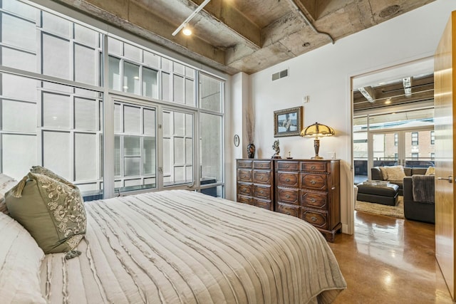 bedroom with a towering ceiling, visible vents, and finished concrete floors