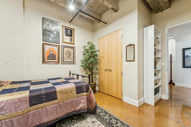 bedroom with finished concrete floors and baseboards