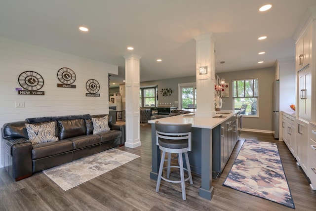 kitchen featuring recessed lighting, decorative columns, and open floor plan