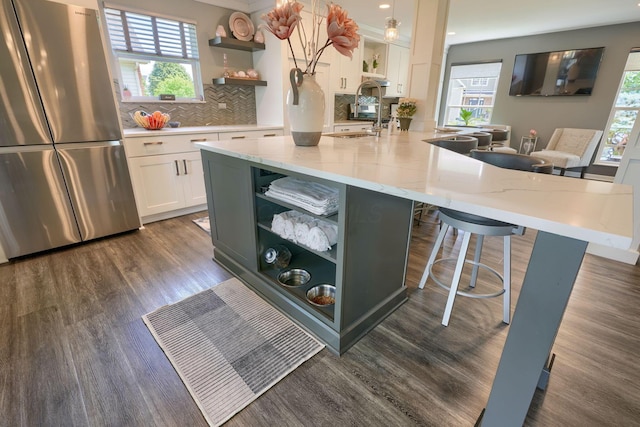 kitchen featuring freestanding refrigerator, open shelves, a wealth of natural light, and dark wood-style flooring