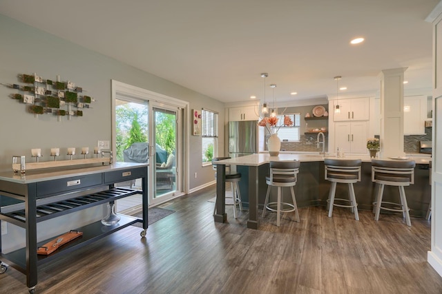 kitchen featuring dark wood-style floors, a sink, white cabinetry, and plenty of natural light