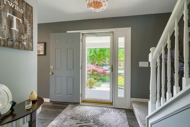 entrance foyer with baseboards, stairs, and dark wood-type flooring