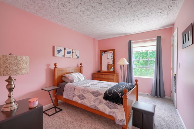 bedroom featuring a textured ceiling, light carpet, and baseboards