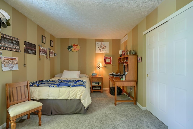 carpeted bedroom featuring baseboards and a textured ceiling