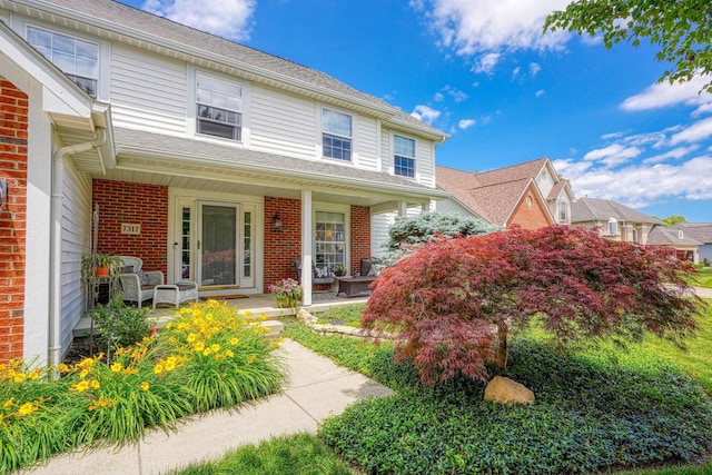 traditional-style home with covered porch and brick siding