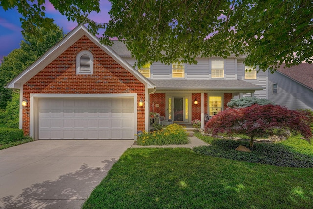 traditional-style home with driveway, a yard, an attached garage, and brick siding
