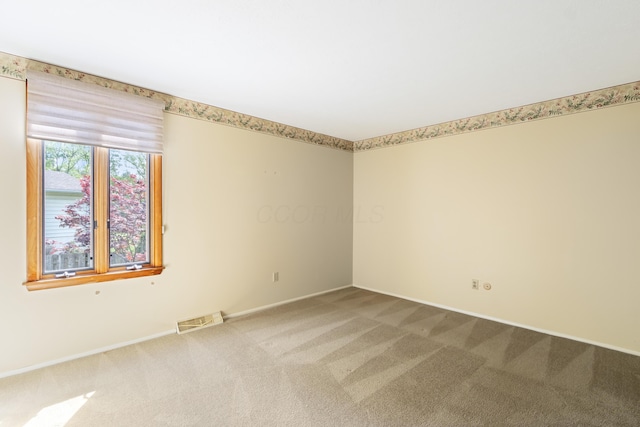 empty room featuring carpet flooring and baseboards