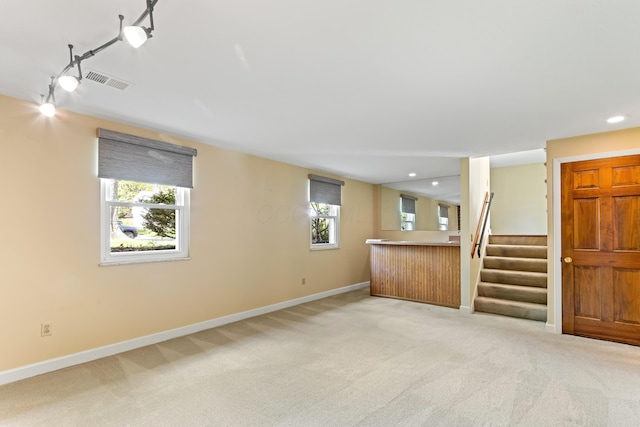 unfurnished living room with light carpet, baseboards, healthy amount of natural light, and recessed lighting