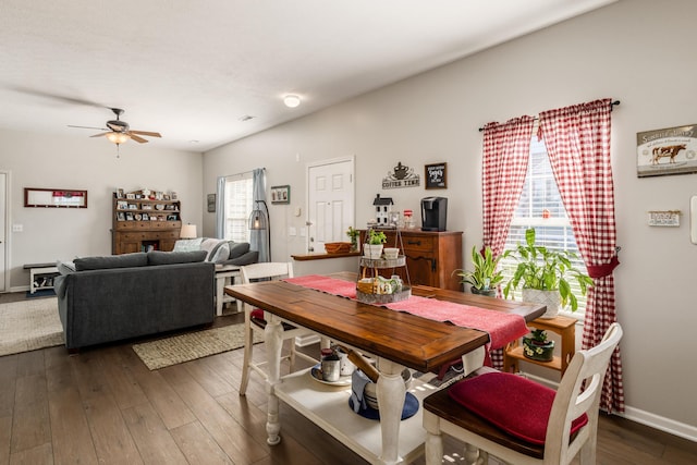 dining space with dark wood-style flooring, baseboards, and ceiling fan