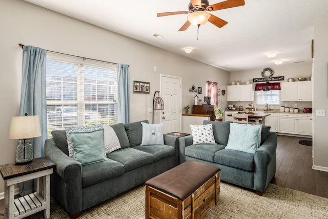 living area featuring hardwood / wood-style flooring, visible vents, and a ceiling fan