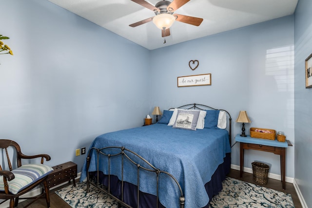 bedroom featuring wood finished floors, a ceiling fan, and baseboards