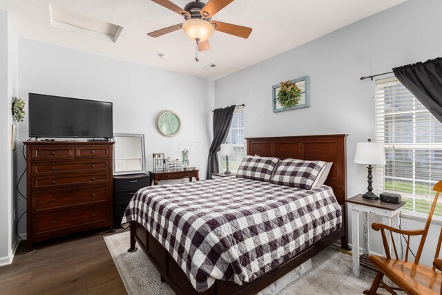 bedroom featuring attic access, wood finished floors, and multiple windows