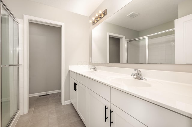 full bath featuring double vanity, a shower stall, and a sink