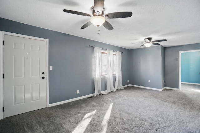 empty room with a textured ceiling, ceiling fan, baseboards, carpet flooring, and visible vents