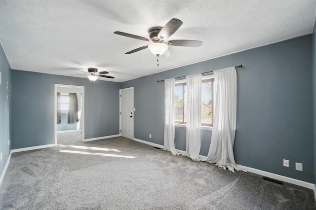 unfurnished room with baseboards, visible vents, ceiling fan, and a healthy amount of sunlight