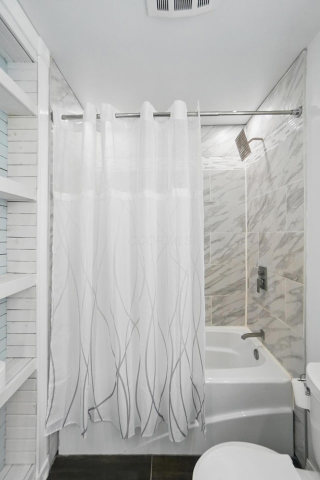 bathroom featuring shower / tub combo, toilet, and visible vents