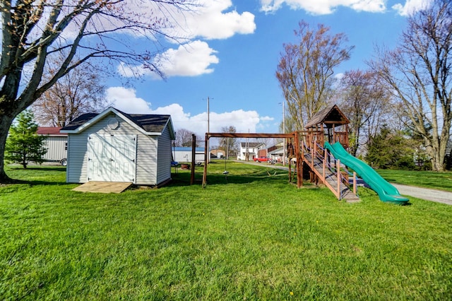 view of jungle gym featuring a lawn, a storage unit, and an outbuilding