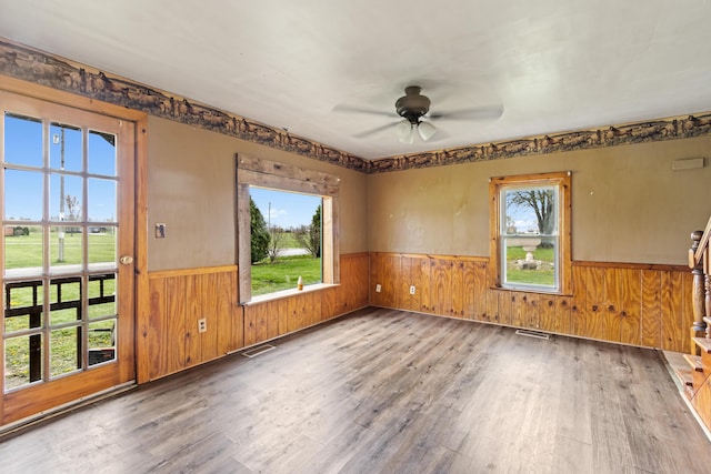 720 Green Cook Rd, Sunbury, OH 43074 - empty room with a wainscoted wall, wooden walls, wood finished floors, visible vents, and ceiling fan