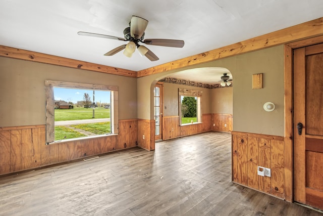 720 Green Cook Rd, Sunbury, OH 43074 - empty room featuring arched walkways, wood walls, ceiling fan, and wainscoting