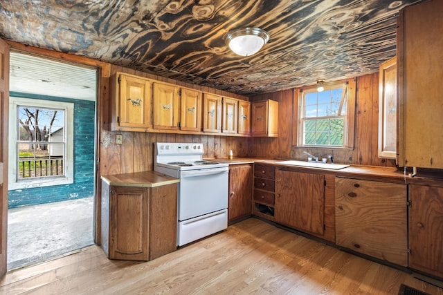 720 Green Cook Rd, Sunbury, OH 43074 - kitchen with light wood-style flooring, a sink, white electric range, brown cabinets, and wooden walls