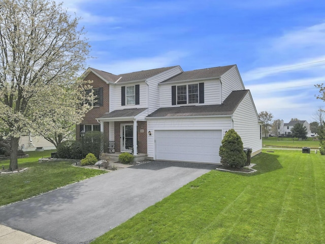 traditional-style home featuring an attached garage, a front lawn, driveway, and brick siding
