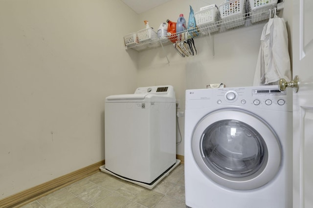laundry room with separate washer and dryer, baseboards, and laundry area