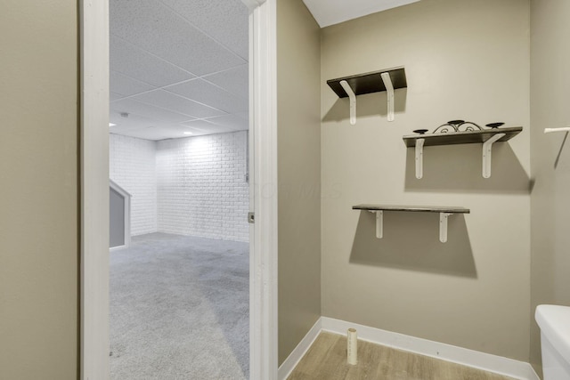 bathroom featuring toilet, baseboards, and a drop ceiling