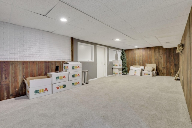 game room with wooden walls, a paneled ceiling, and carpet floors