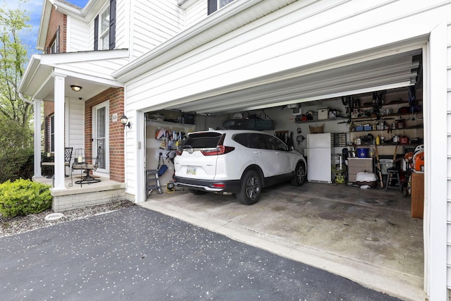 garage featuring covered porch and aphalt driveway